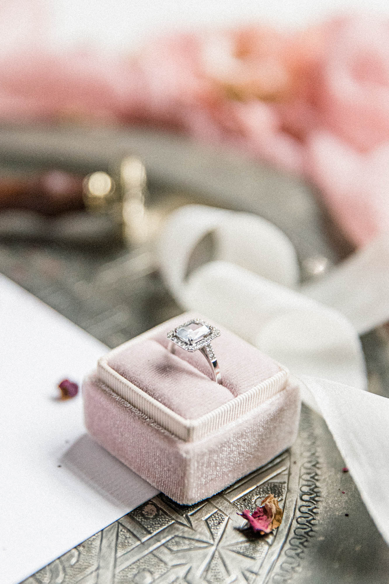 Bague de fiançailles dans un écrin en velours rose sur un plateau en argent