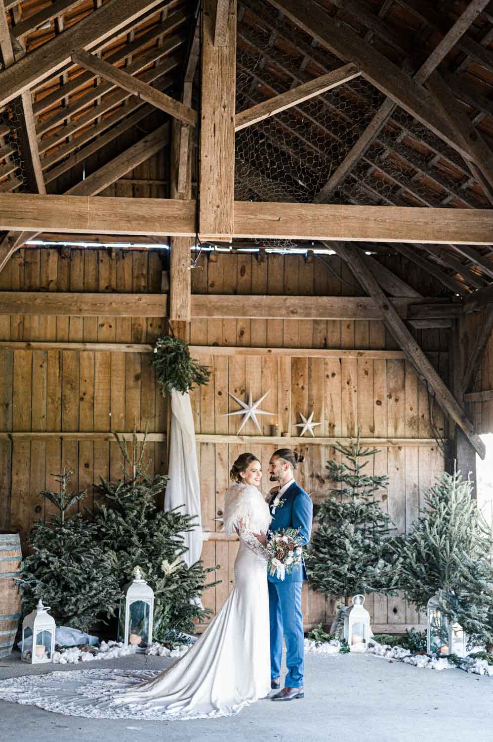 Mariés dans une grange en bois décorée de sapins à La Grange de Nicolas