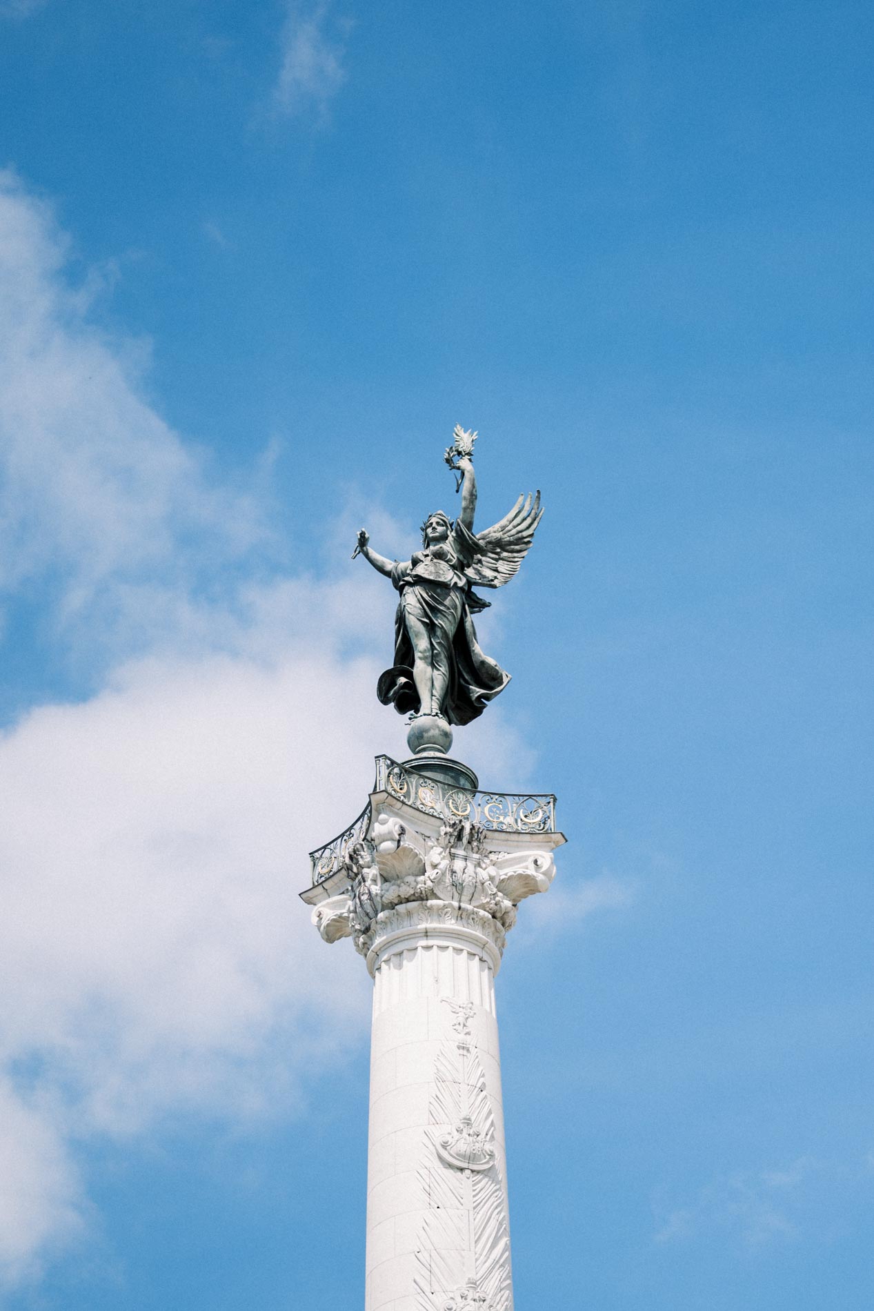 Colonne surmontée d'une statue ailée sous un ciel bleu, EVJF à Bordeaux