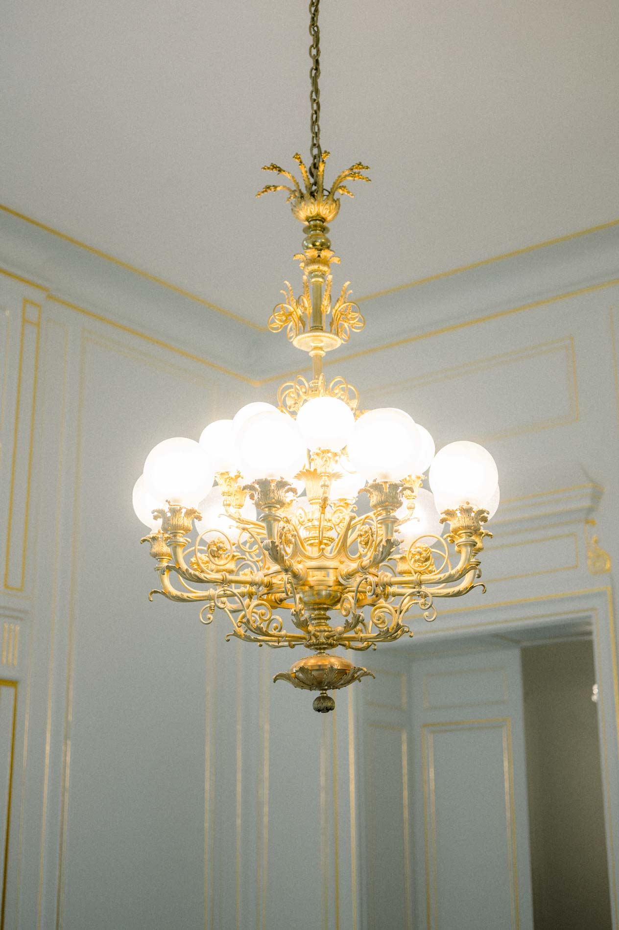 Lustre doré dans un salon blanc de la mairie de Bordeaux