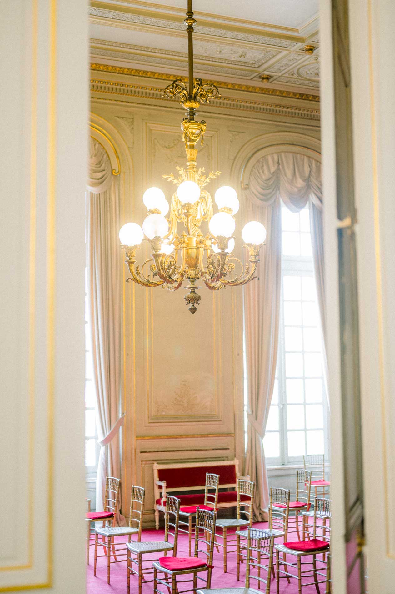 Salle des mariages de la mairie de Bordeaux avec lustre et fauteuils rouges