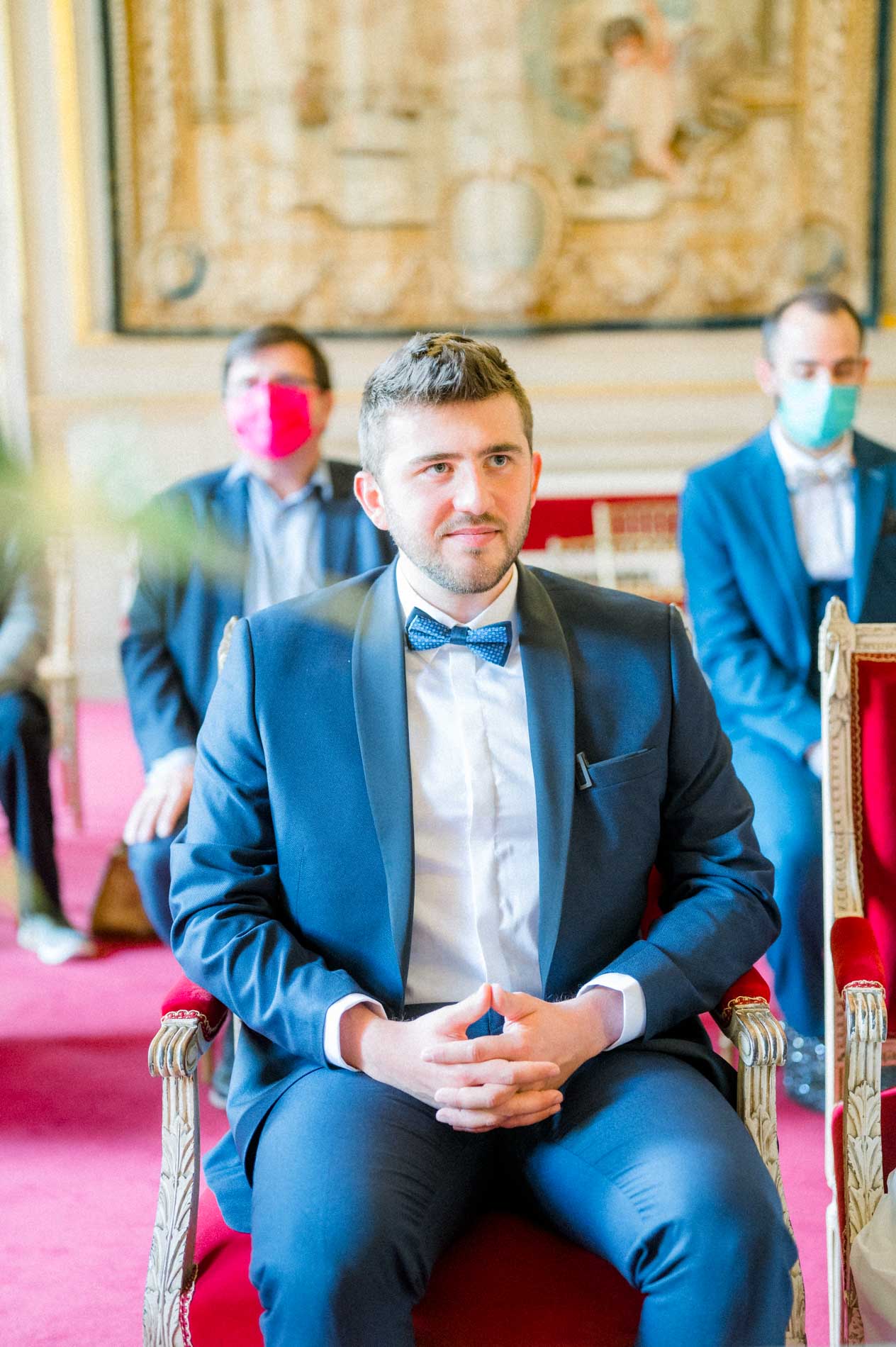 Marié assis dans un fauteuil rouge pendant la cérémonie à la mairie