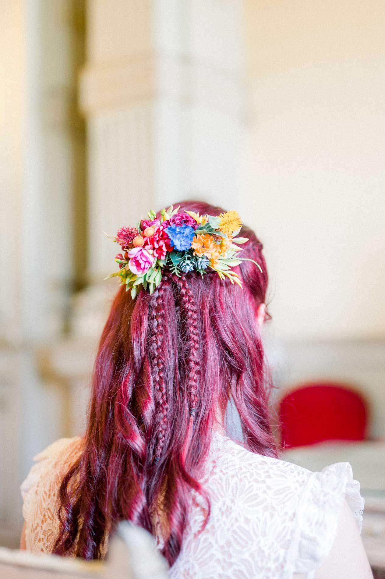 Coiffure tressée de la mariée ornée de fleurs colorées, vue de dos