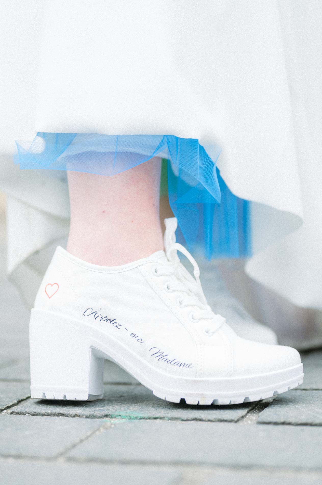 Bottines blanches à plateforme de la mariée sous sa robe