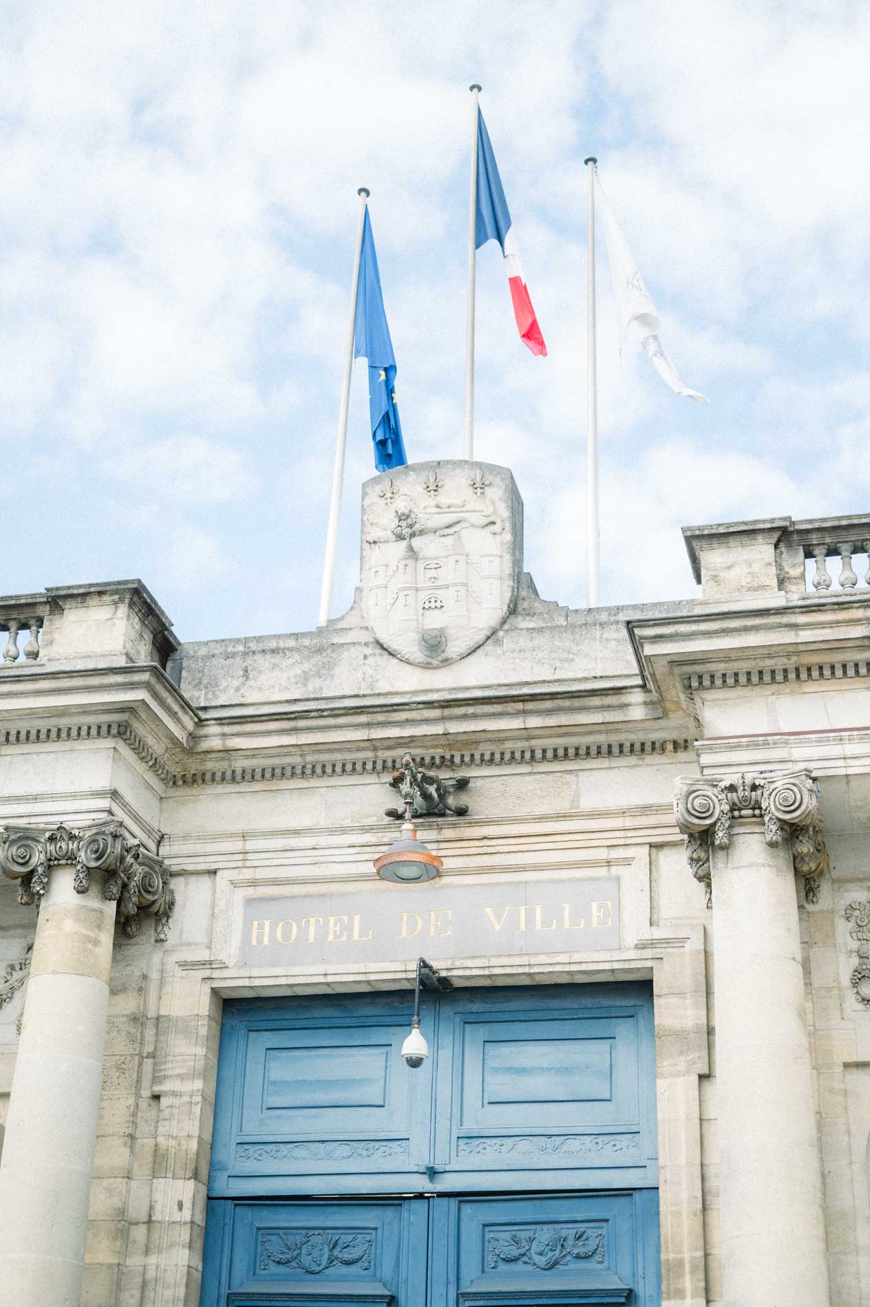 Entrée de l'Hôtel de Ville de Bordeaux avec portail bleu et drapeaux