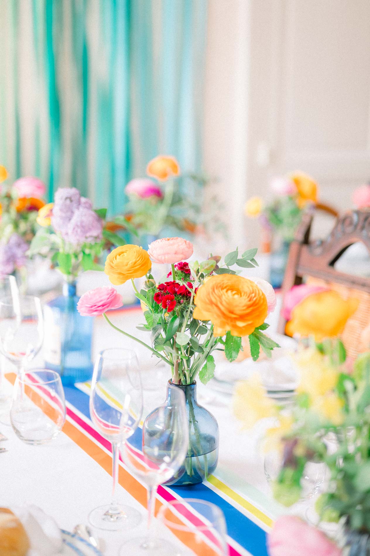 Table de réception décorée de fleurs vives et d'un chemin de table rayé