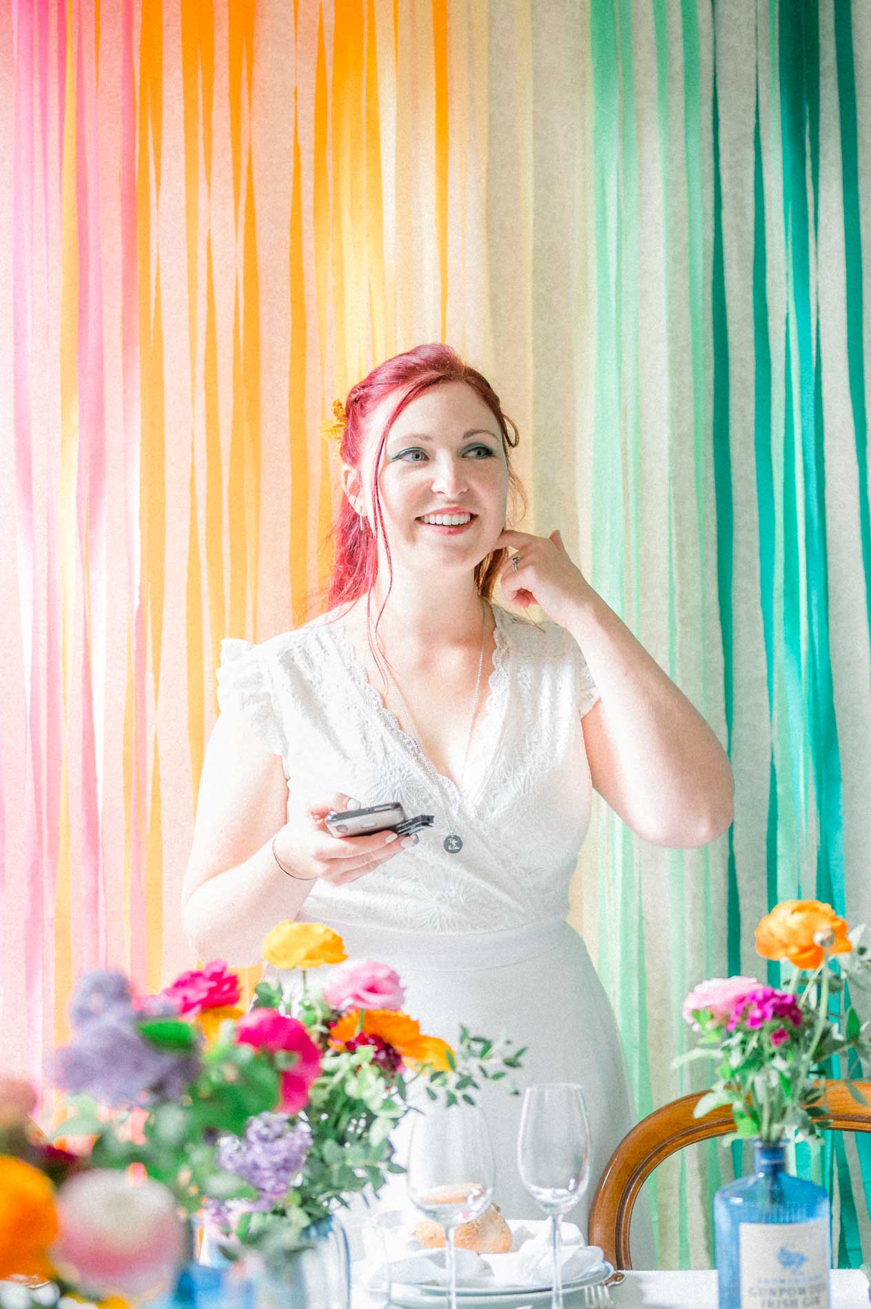 Mariée rêveuse devant la toile de fond en rubans arc-en-ciel
