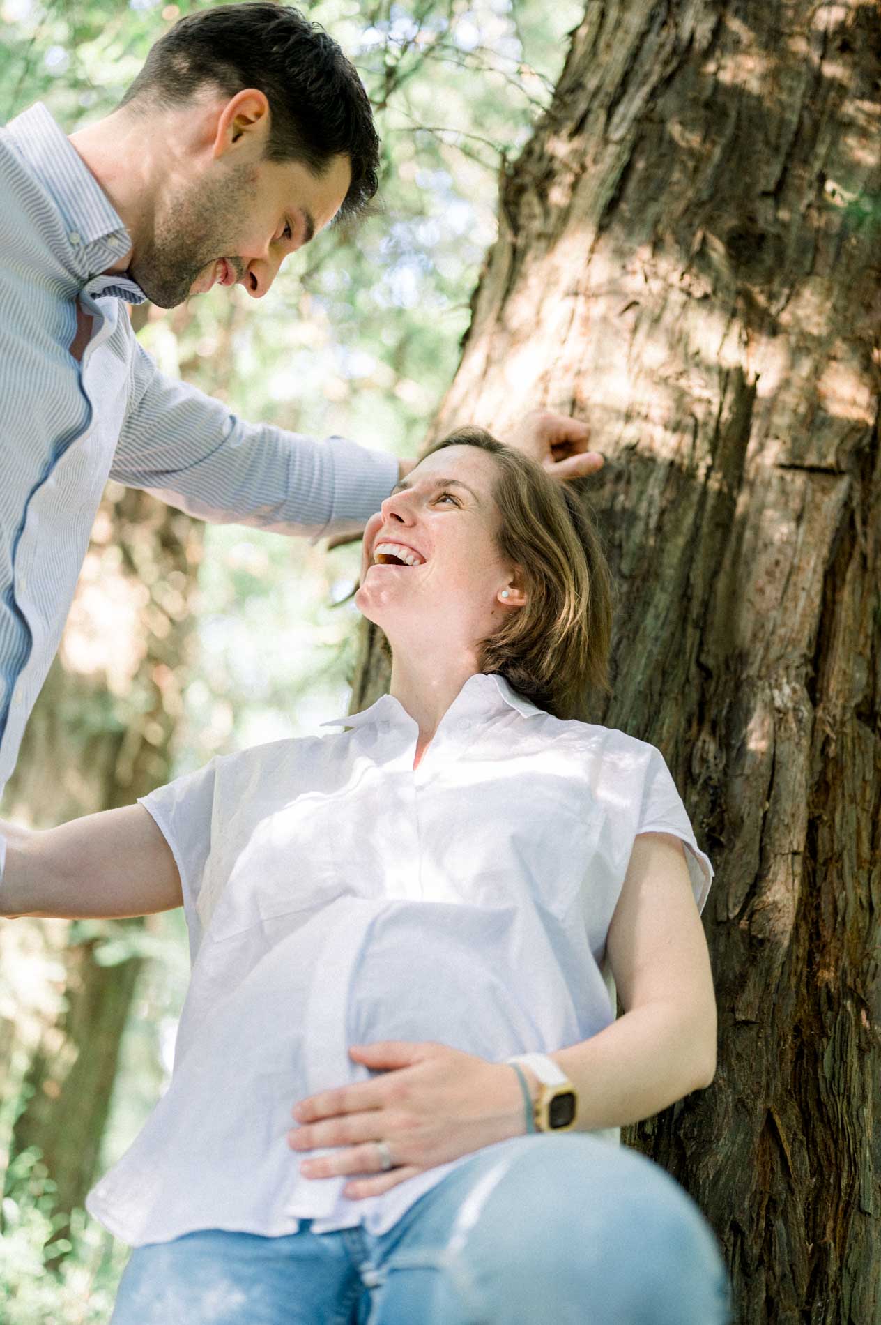 Future maman souriante levant les yeux vers son compagnon penché