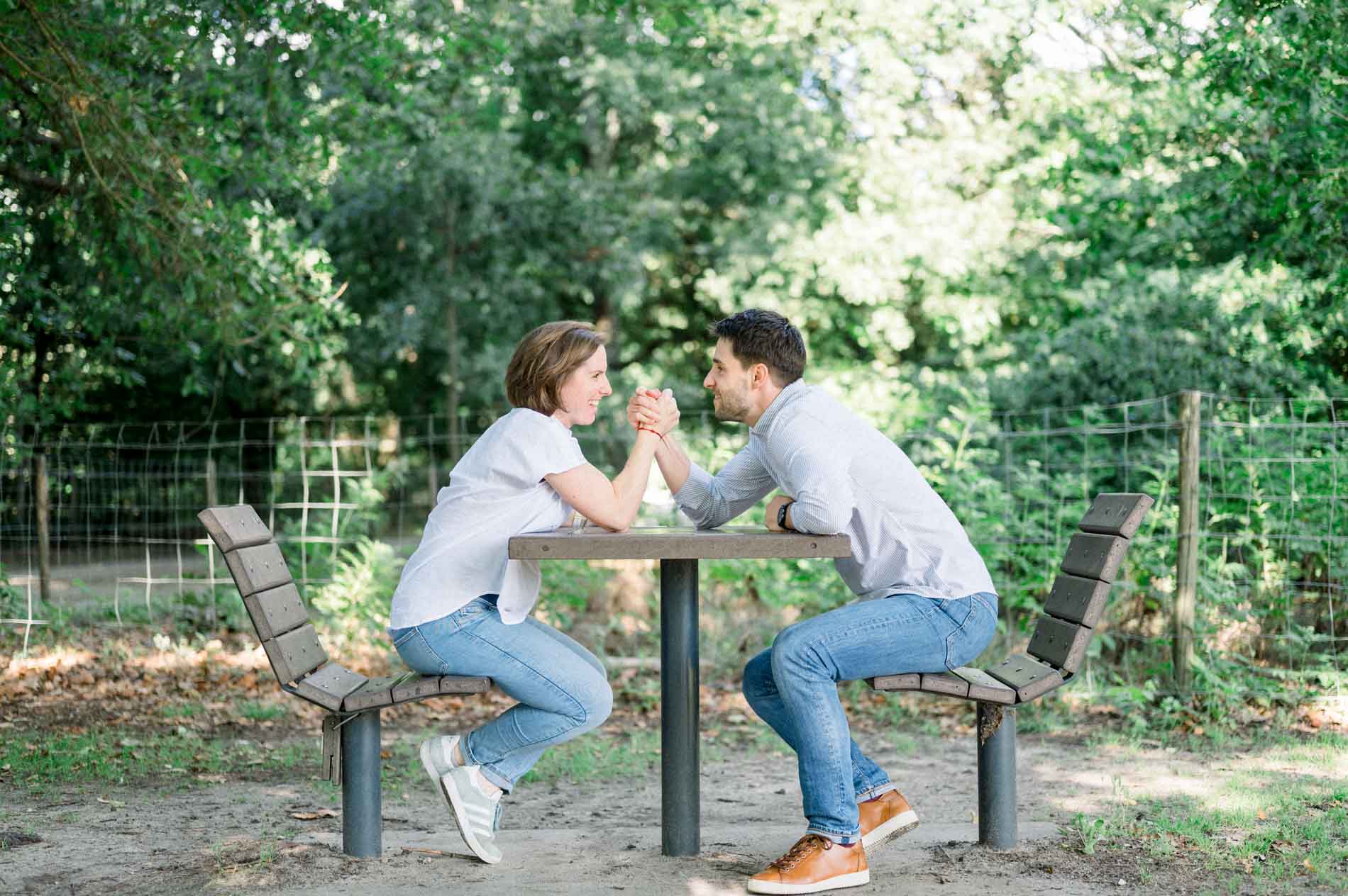 Futurs parents faisant un bras de fer sur une table de pique-nique