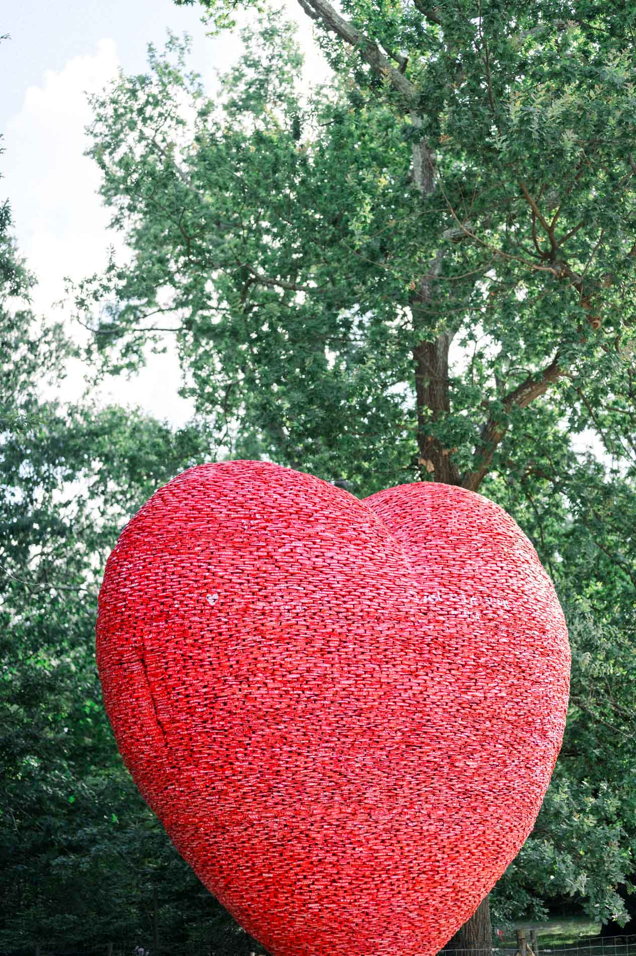 Grand cœur rouge sculpté devant les arbres du Parc Bordelais