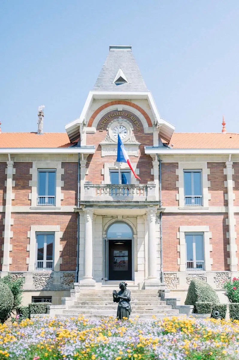 La mairie de Soulac-sur-Mer et son parterre fleuri sous un ciel bleu