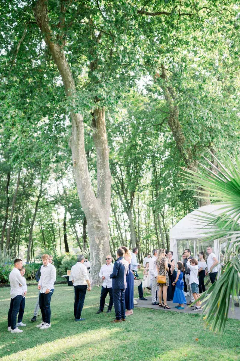 Les invités réunis à l'ombre des grands arbres pour le vin d'honneur